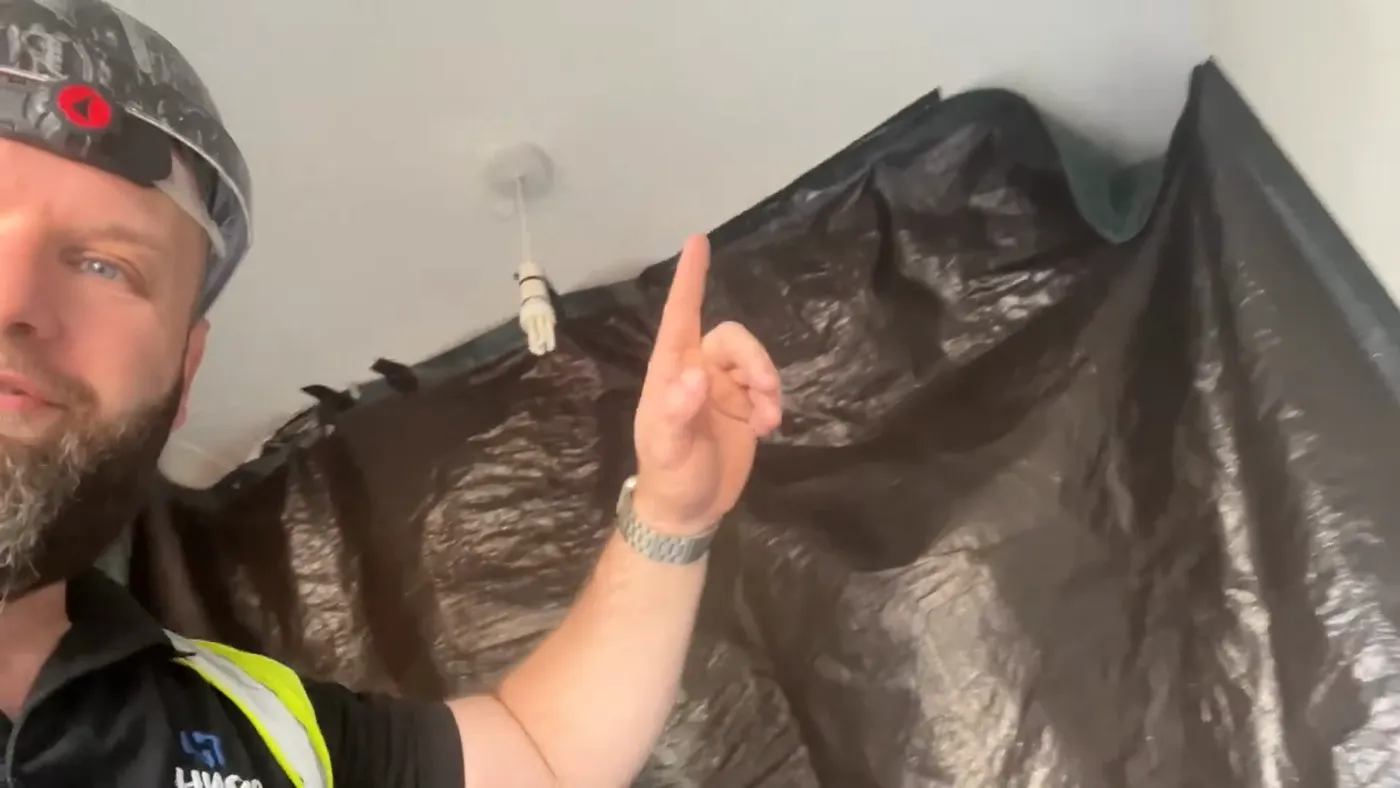A polythene dust sheet taped across a doorway to seal off the rest of the house before any cutting starts.