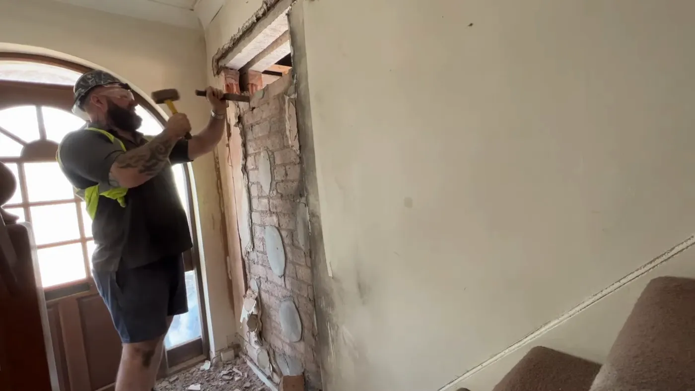 A newly formed doorway opening in an internal wall, lintel in place above and the brickwork below removed.