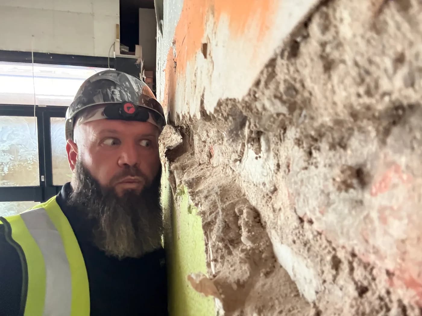Plaster hacked back to bare brickwork on a HYPE job, exposing the wall behind the finish.