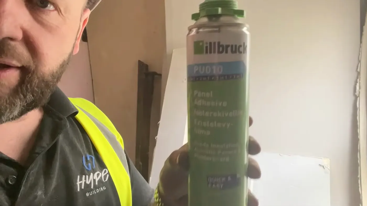 John holding a can of Illbruck PU010 panel adhesive on site.