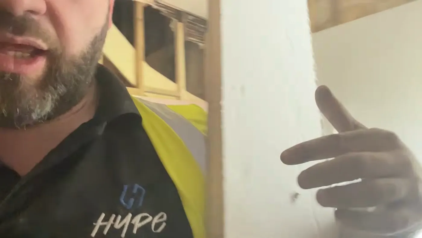 The foil-faced edge of an insulated plasterboard sheet, showing the shiny coating that ordinary adhesive will not grip.