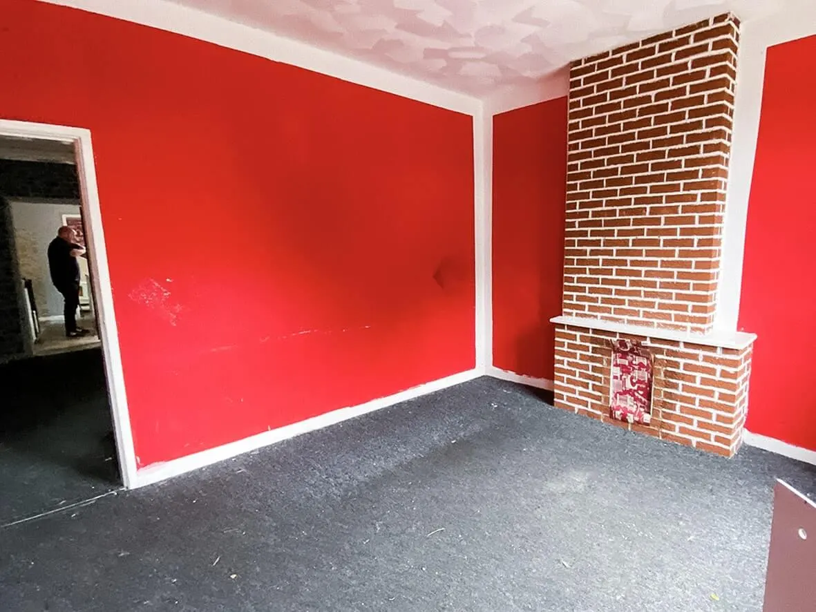 Before · red painted lounge with a fake brick chimney breast