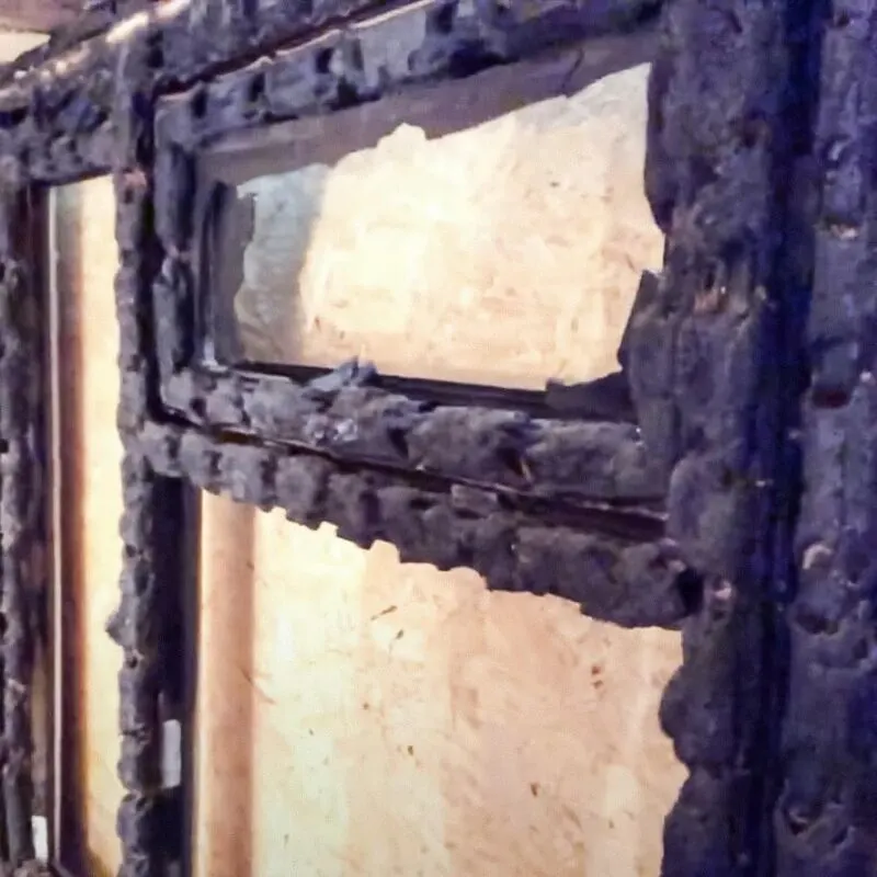 Badly burnt window frame in the living room where the fire started